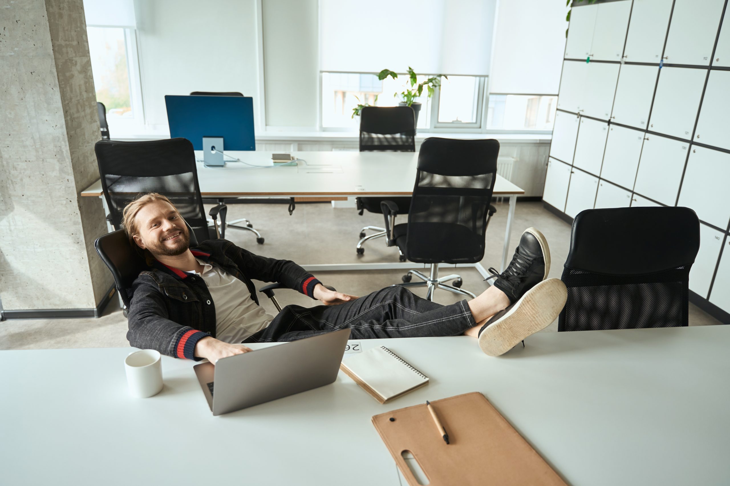 Cheerful male communicates online and drinks coffee