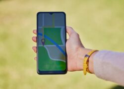Woman, hand and phone for travel map, gps or sightseeing location research in nature park, forest o