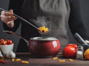 Cooking italian pasta in a pot in the kitchen, Chef preparing food, meal.