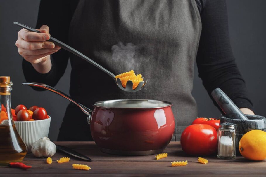 Cooking italian pasta in a pot in the kitchen, Chef preparing food, meal.