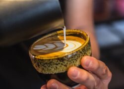 A closeup shot of a male doing a latte art