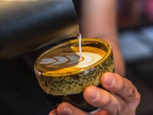 A closeup shot of a male doing a latte art